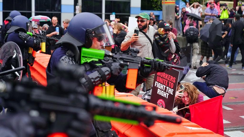 Police offer shooting over crouching protestors from behind barricade